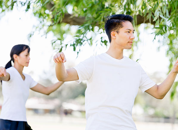 two people doing tai chi in a serene park